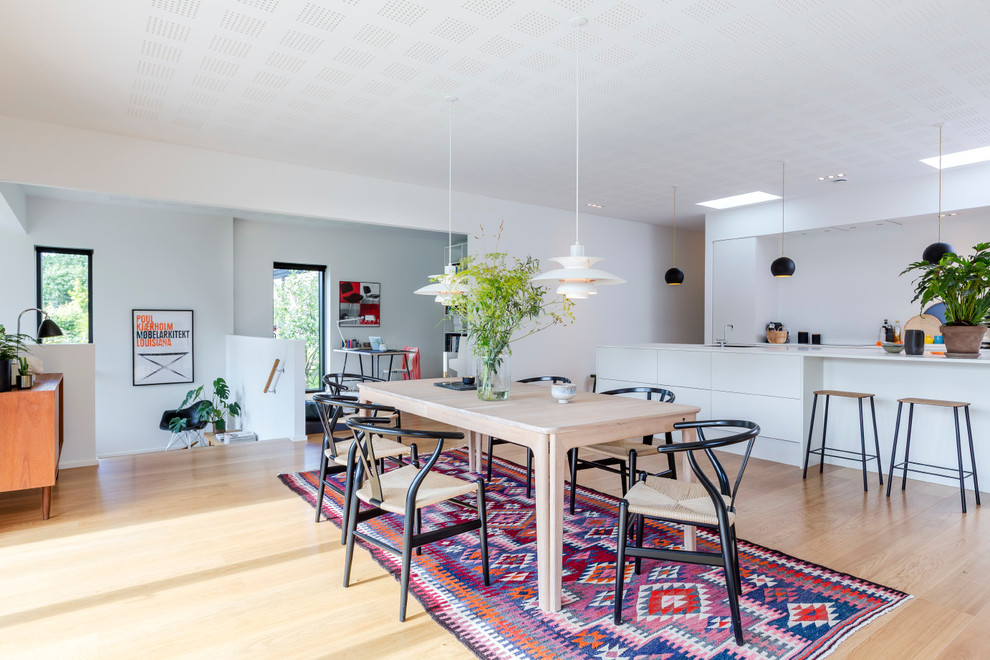 Large scandi dining room in Aarhus with white walls and light hardwood flooring.