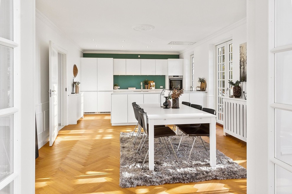 This is an example of a medium sized contemporary kitchen/dining room in Copenhagen with green walls, medium hardwood flooring and brown floors.