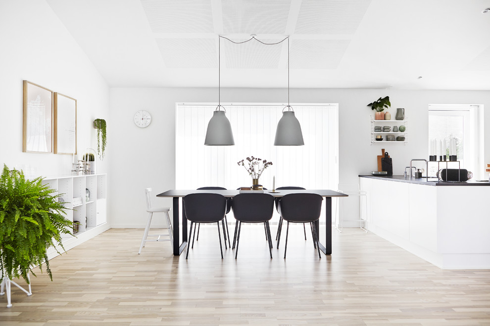 Idées déco pour une salle à manger ouverte sur la cuisine scandinave de taille moyenne avec un mur blanc, parquet clair et aucune cheminée.