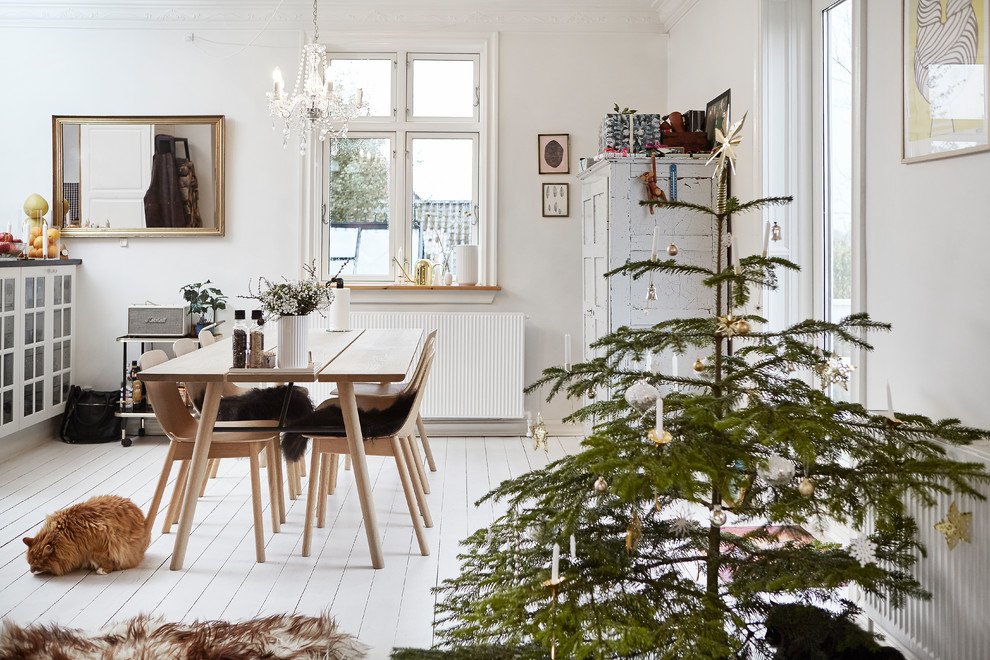На фото: кухня-столовая среднего размера в скандинавском стиле с белыми стенами, деревянным полом и белым полом
