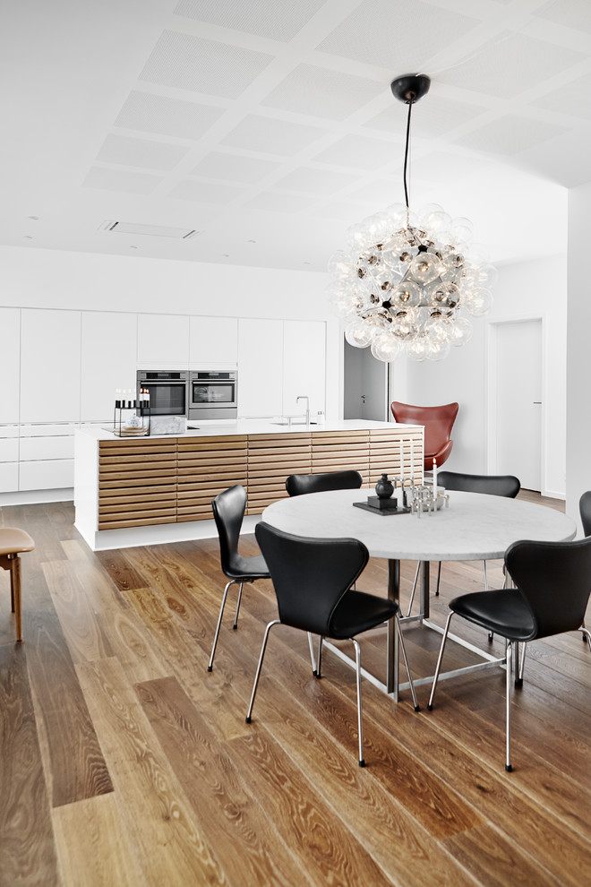 Esempio di una sala da pranzo aperta verso la cucina moderna di medie dimensioni con pavimento in legno massello medio