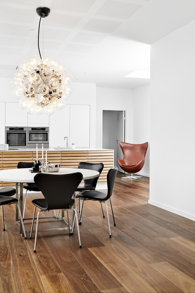 Esempio di una sala da pranzo moderna di medie dimensioni con pavimento in legno massello medio e pavimento marrone