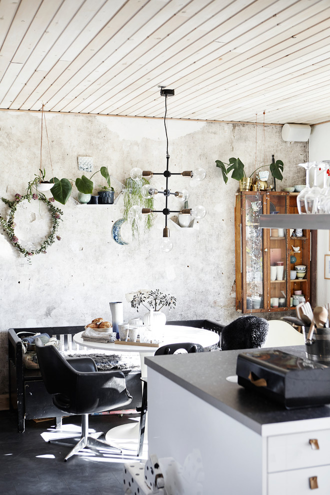 Idee per una sala da pranzo aperta verso la cucina eclettica di medie dimensioni con pareti grigie, pavimento in cemento e pavimento grigio