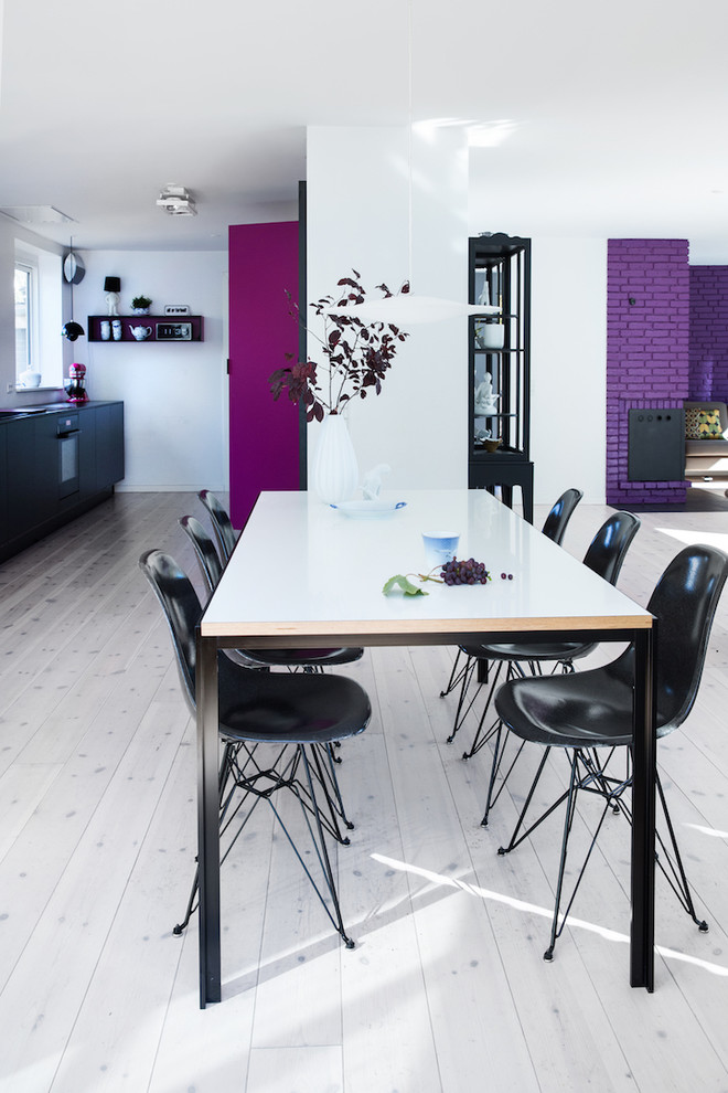 Offenes Modernes Esszimmer mit lila Wandfarbe, hellem Holzboden und grauem Boden in Kopenhagen