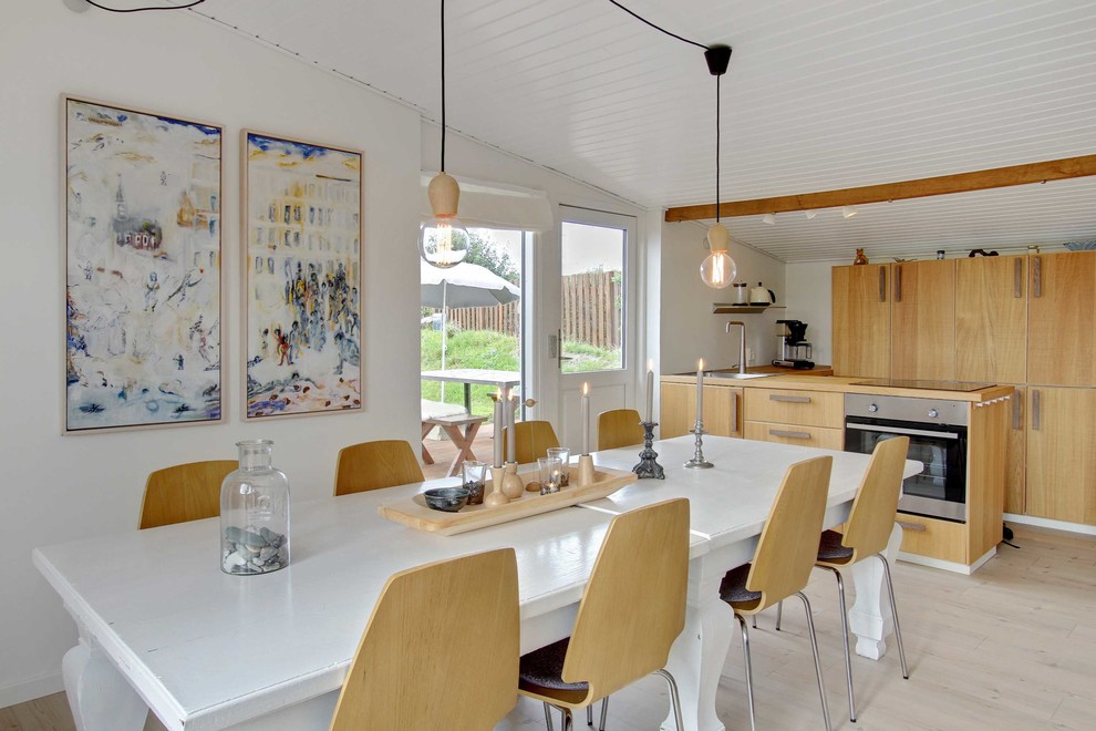 Example of a mid-sized danish light wood floor kitchen/dining room combo design in Odense with white walls and no fireplace