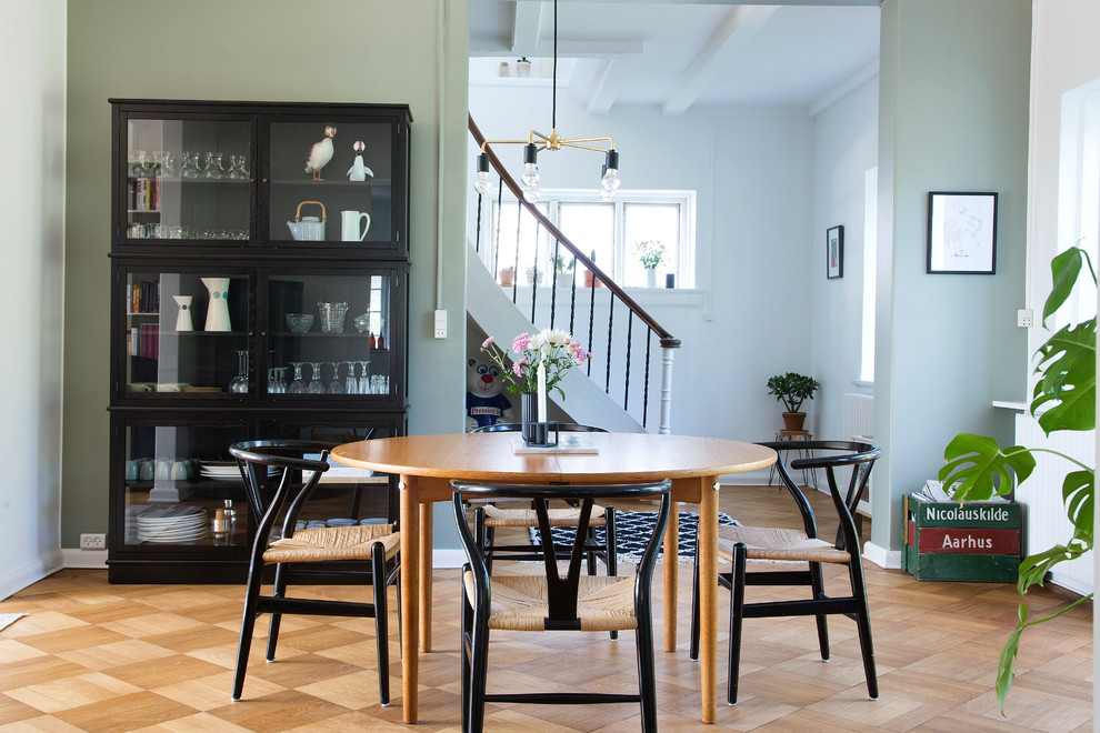 Exemple d'une salle à manger scandinave avec un mur vert et un sol en bois brun.