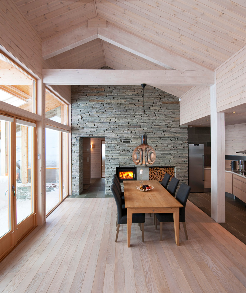 Nordische Wohnküche mit hellem Holzboden und Kaminofen in Sonstige
