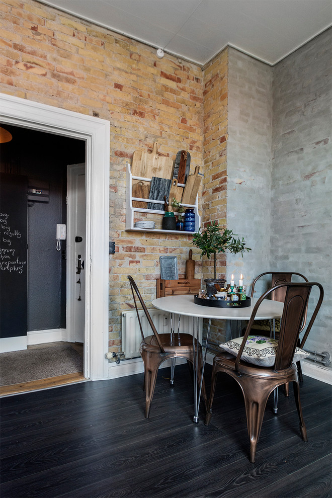 Cette photo montre une salle à manger industrielle avec un mur marron, parquet foncé et un sol noir.
