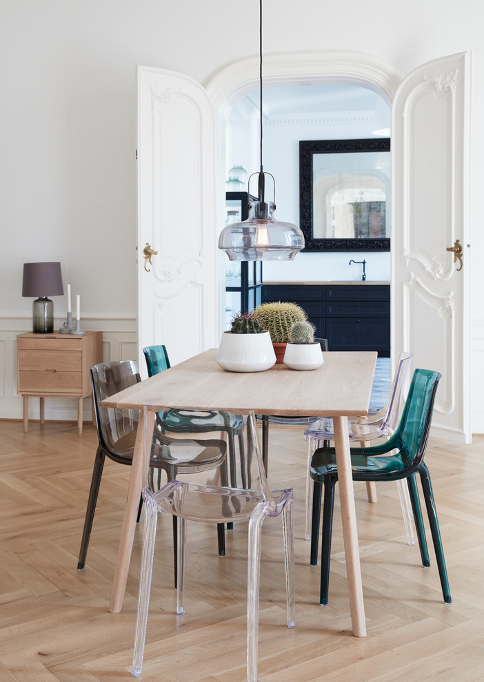 Example of a large danish light wood floor enclosed dining room design in Esbjerg with white walls and no fireplace