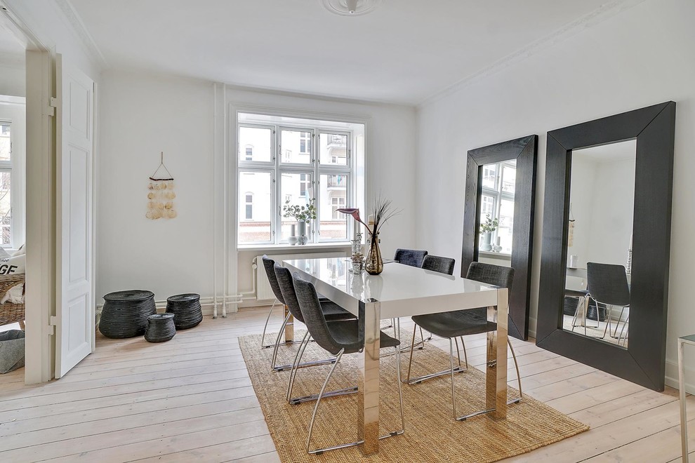 Design ideas for a medium sized scandinavian enclosed dining room in Copenhagen with white walls, light hardwood flooring and beige floors.
