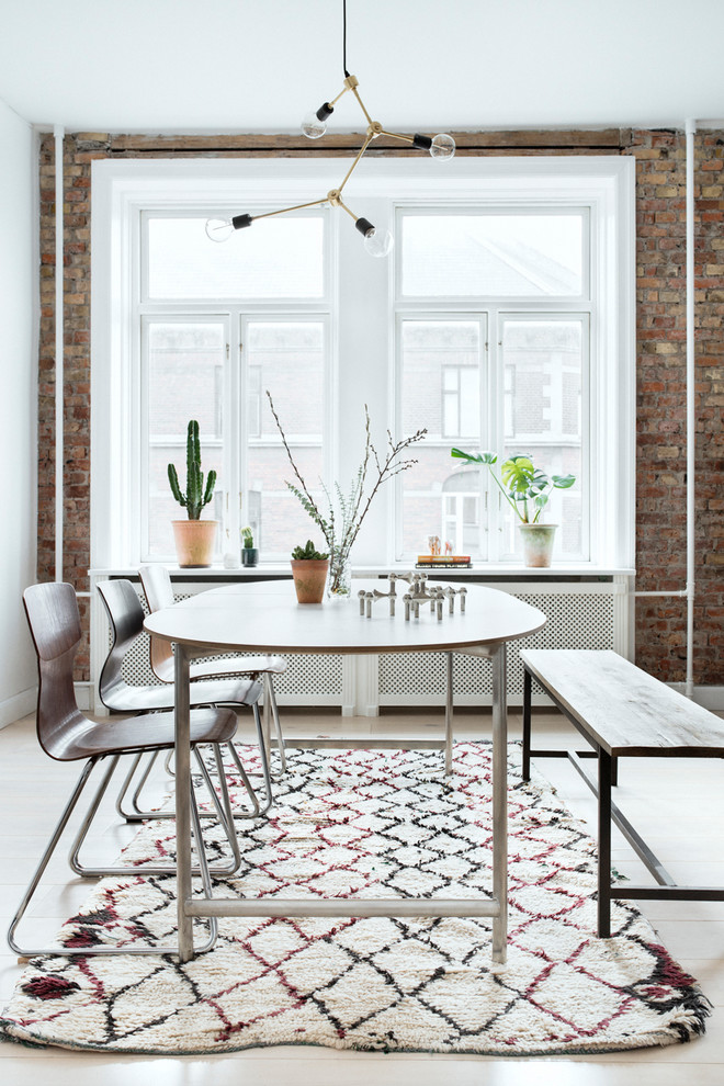 На фото: столовая в скандинавском стиле с белыми стенами и светлым паркетным полом