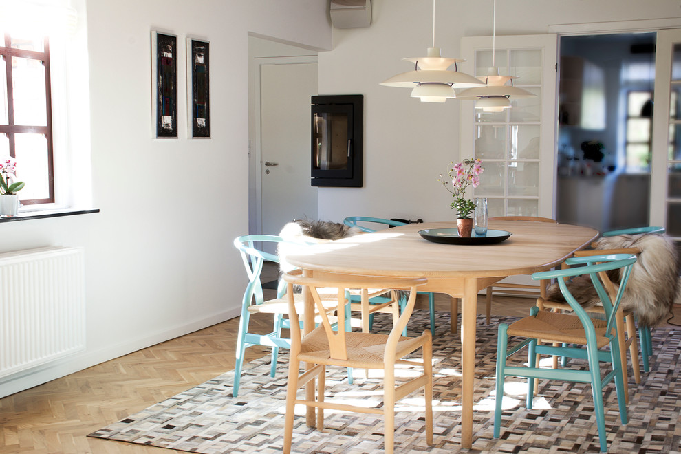 Inredning av ett minimalistiskt kök med matplats, med vita väggar och en öppen hörnspis