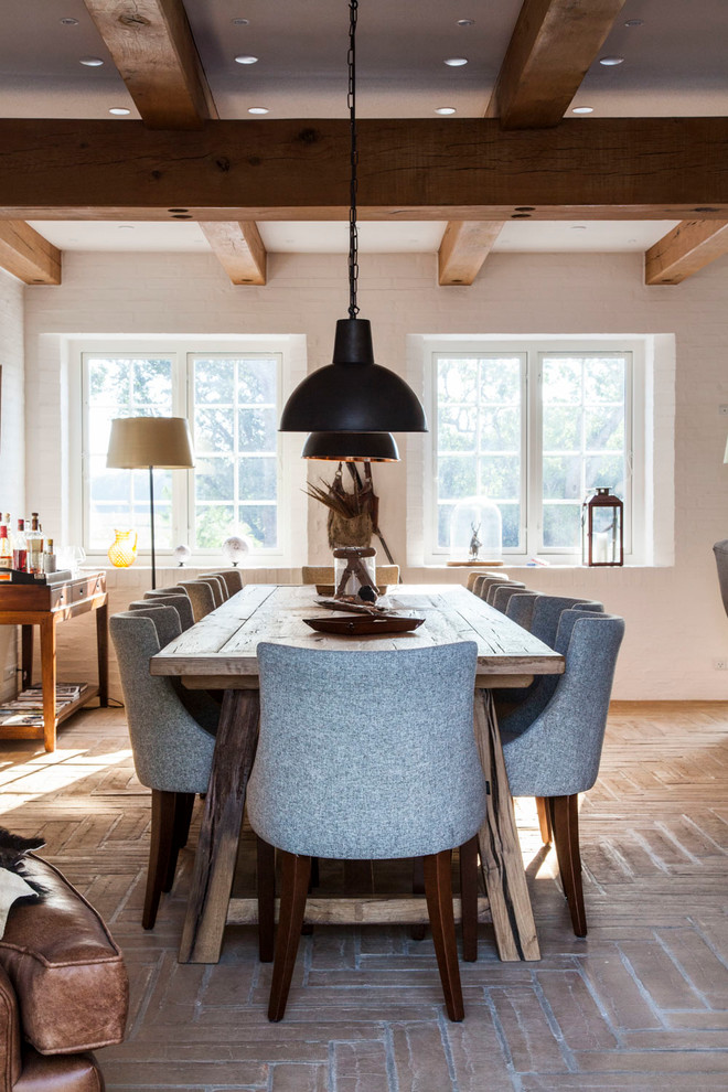 This is an example of a medium sized rustic enclosed dining room in Odense with white walls and brick flooring.