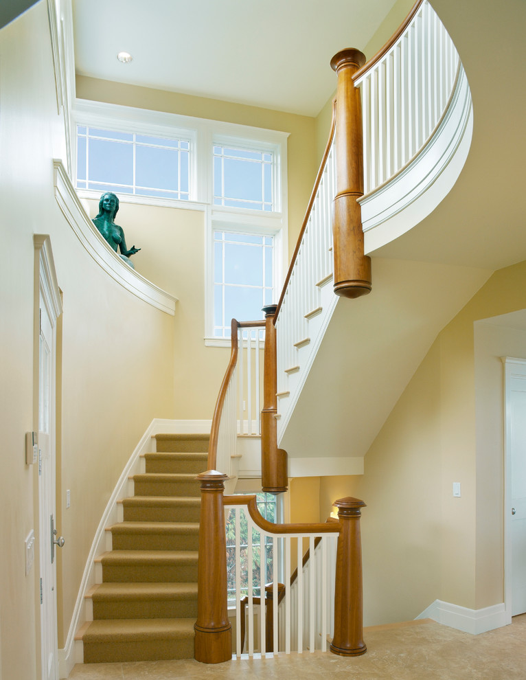 Idée de décoration pour un escalier courbe tradition de taille moyenne avec des marches en moquette et des contremarches en bois.