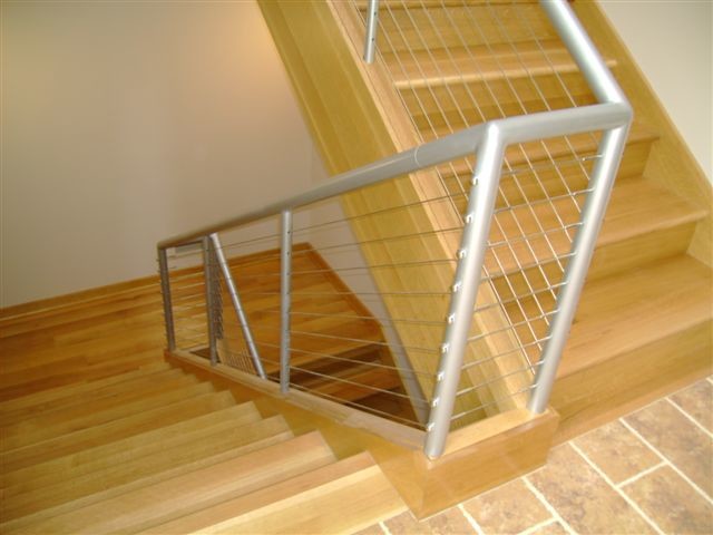 ワシントンD.C.にある高級な中くらいなインダストリアルスタイルのおしゃれな折り返し階段 (木の蹴込み板、混合材の手すり) の写真