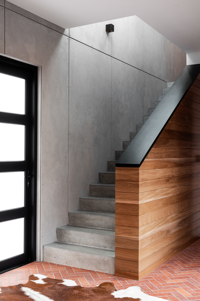Diseño de escalera recta industrial con escalones de hormigón, contrahuellas de hormigón y barandilla de varios materiales