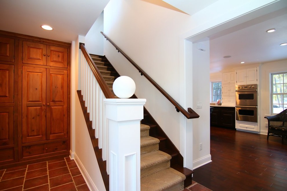 На фото: прямая деревянная лестница среднего размера в стиле кантри с ступенями с ковровым покрытием