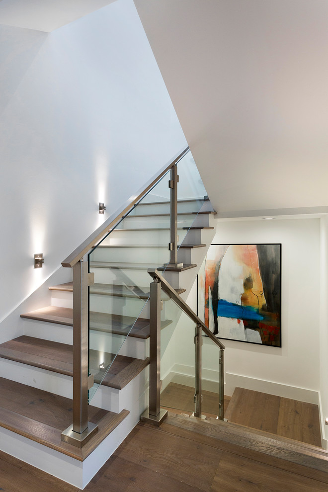 Idée de décoration pour un escalier design en U de taille moyenne avec des marches en bois, des contremarches en bois et un garde-corps en verre.