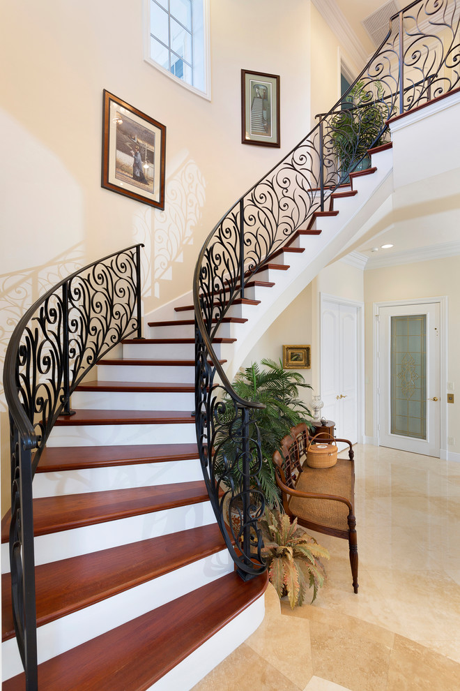 Стильный дизайн: изогнутая деревянная лестница среднего размера в морском стиле с деревянными ступенями и металлическими перилами - последний тренд