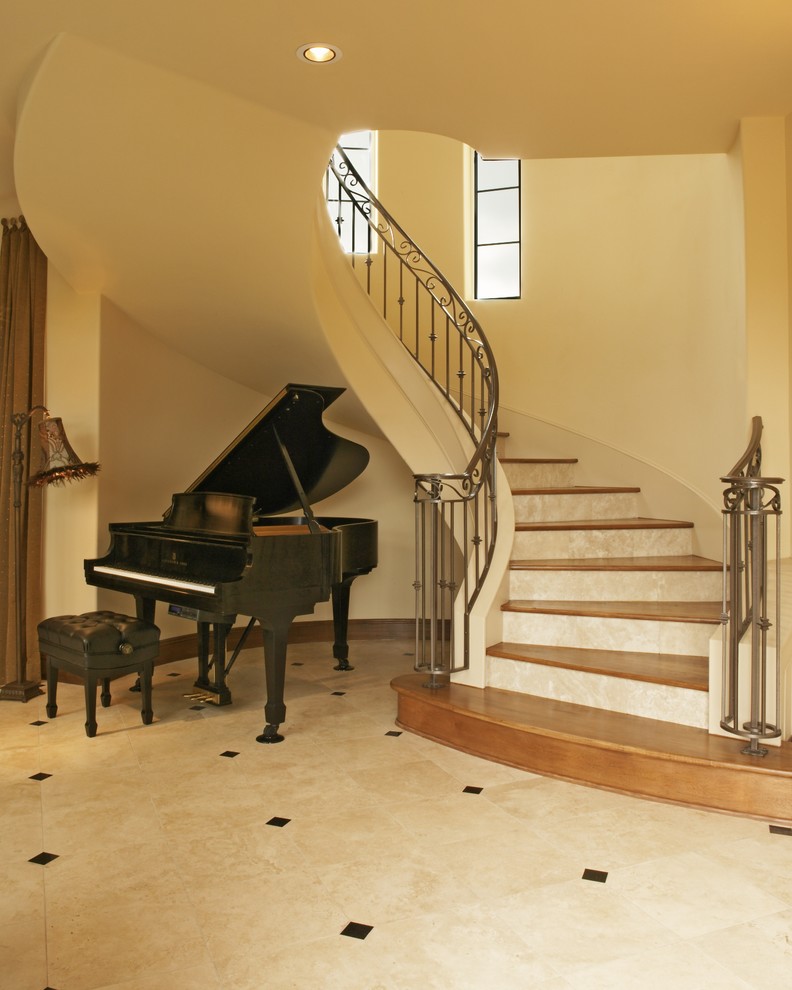 This is an example of a mediterranean wood staircase in Austin with travertine risers.