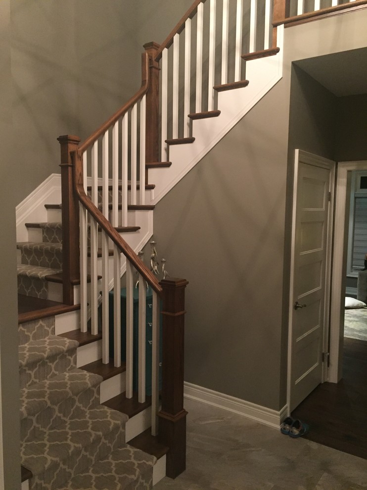 Foto de escalera en U clásica grande con escalones de madera, contrahuellas de madera pintada y barandilla de madera