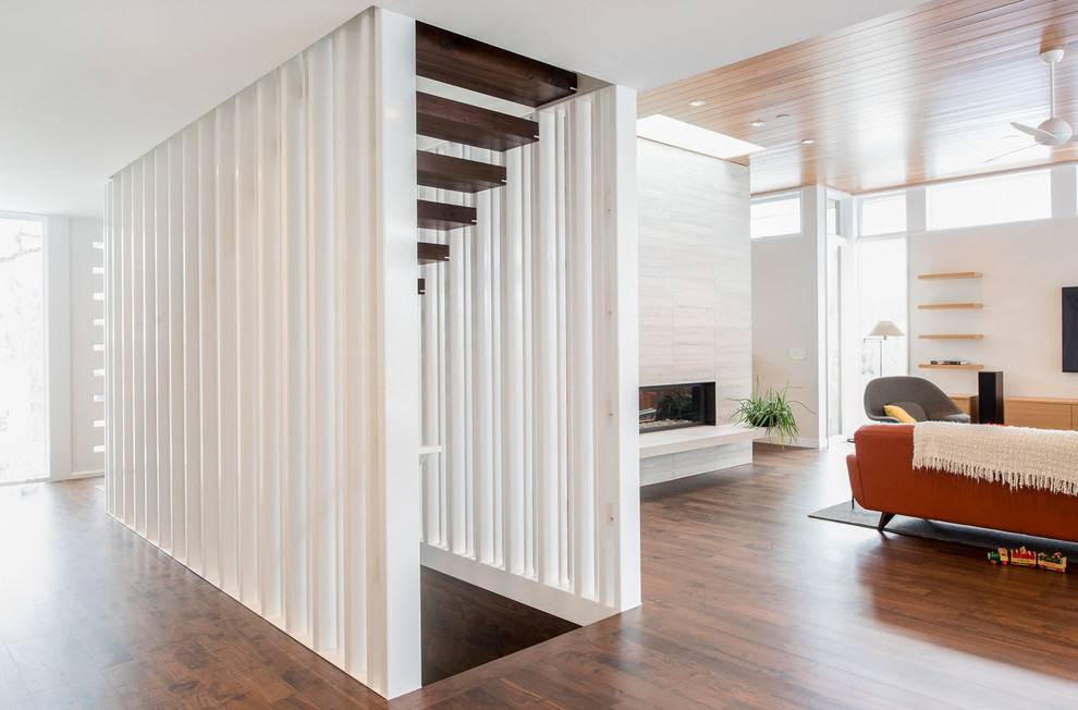 This is an example of a modern wood straight staircase in Minneapolis with open risers and feature lighting.