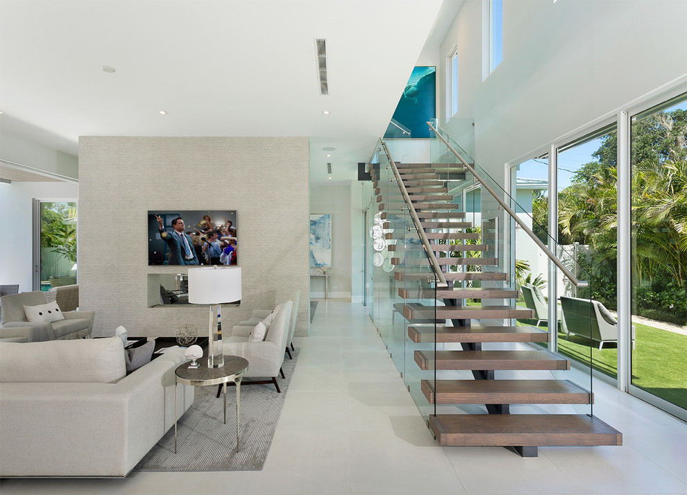 Foto de escalera recta moderna de tamaño medio con contrahuellas de vidrio y barandilla de metal