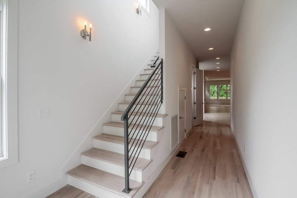 Пример оригинального дизайна: прямая лестница среднего размера в стиле модернизм с деревянными ступенями, крашенными деревянными подступенками и металлическими перилами