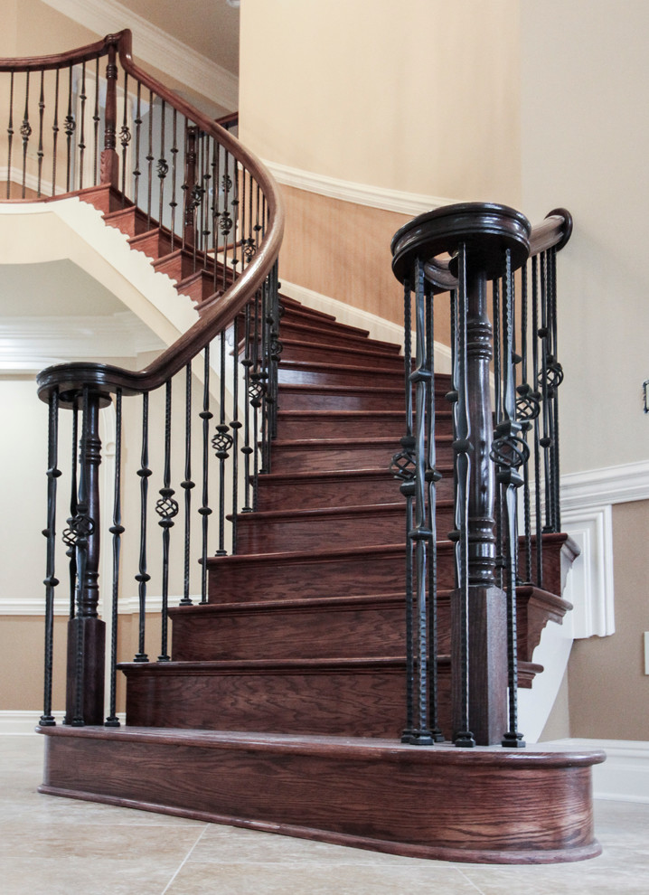 Example of a huge classic wooden curved mixed material railing staircase design in DC Metro with wooden risers