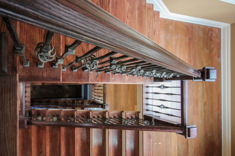 Cette photo montre un très grand escalier courbe chic avec des marches en bois, des contremarches en bois et un garde-corps en matériaux mixtes.