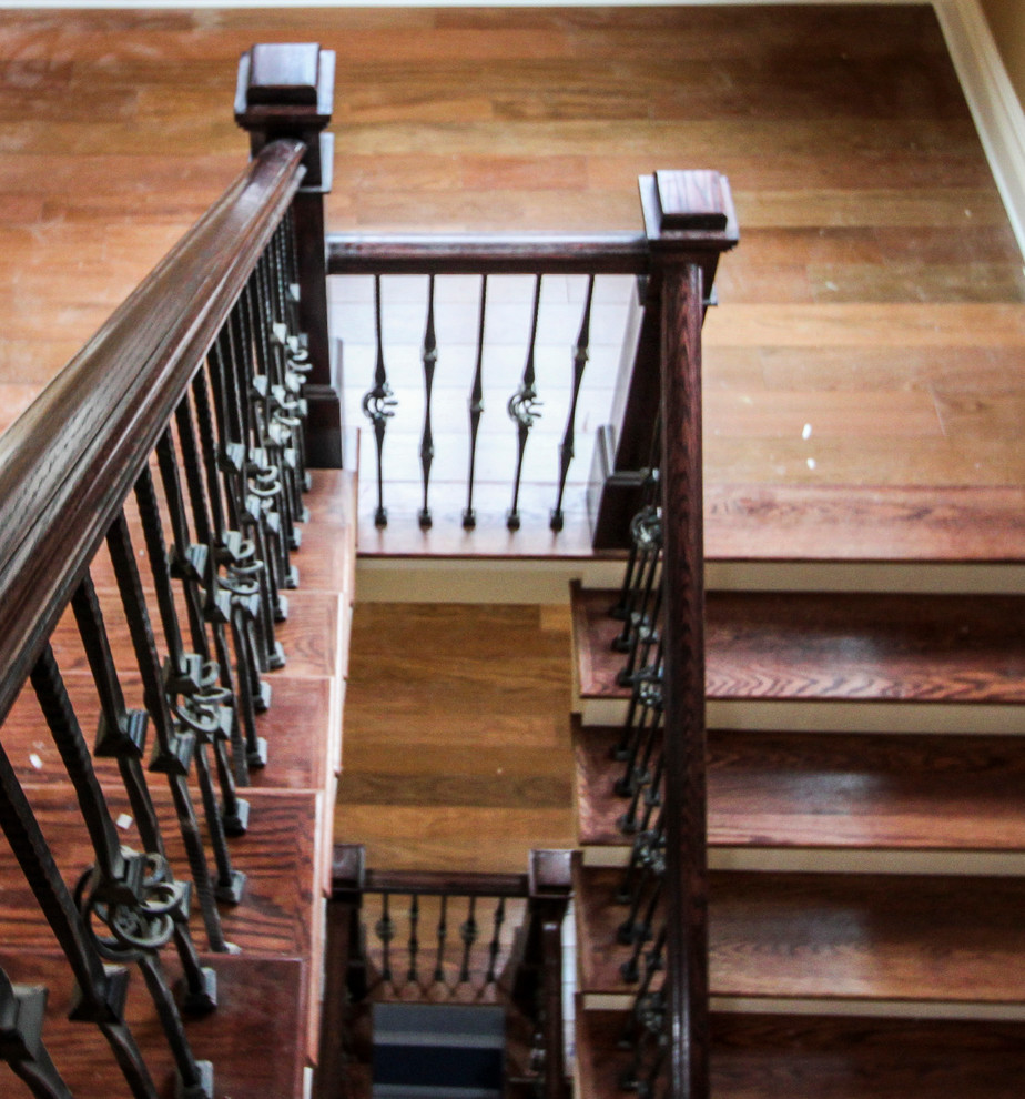 Источник вдохновения для домашнего уюта: огромная изогнутая деревянная лестница в классическом стиле с деревянными ступенями и перилами из смешанных материалов