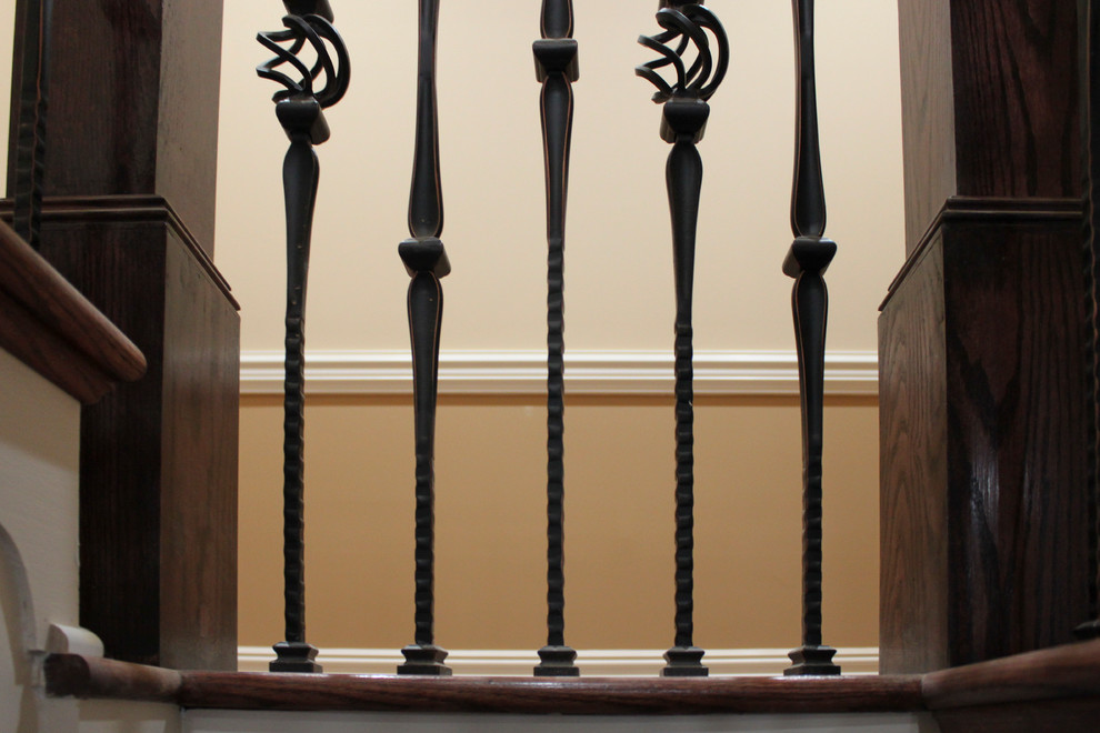 Diseño de escalera curva clásica extra grande con escalones de madera, contrahuellas de madera y barandilla de varios materiales