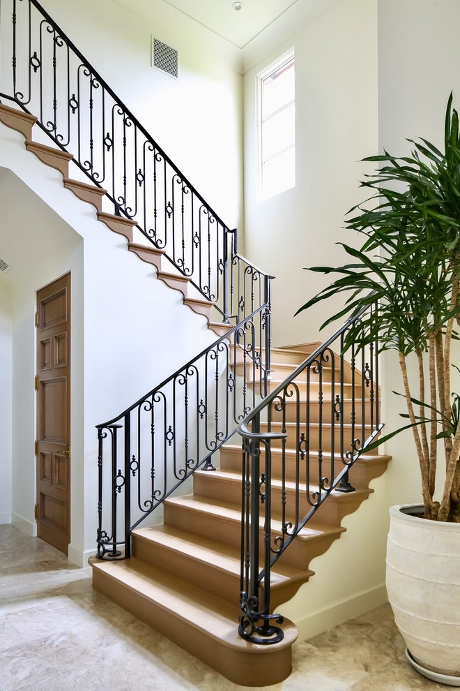 На фото: п-образная деревянная лестница среднего размера в средиземноморском стиле с деревянными ступенями и металлическими перилами с