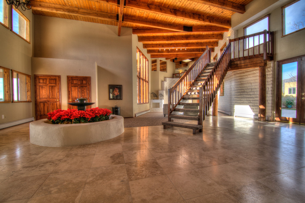 Huge tuscan carpeted floating staircase photo in Albuquerque with wooden risers