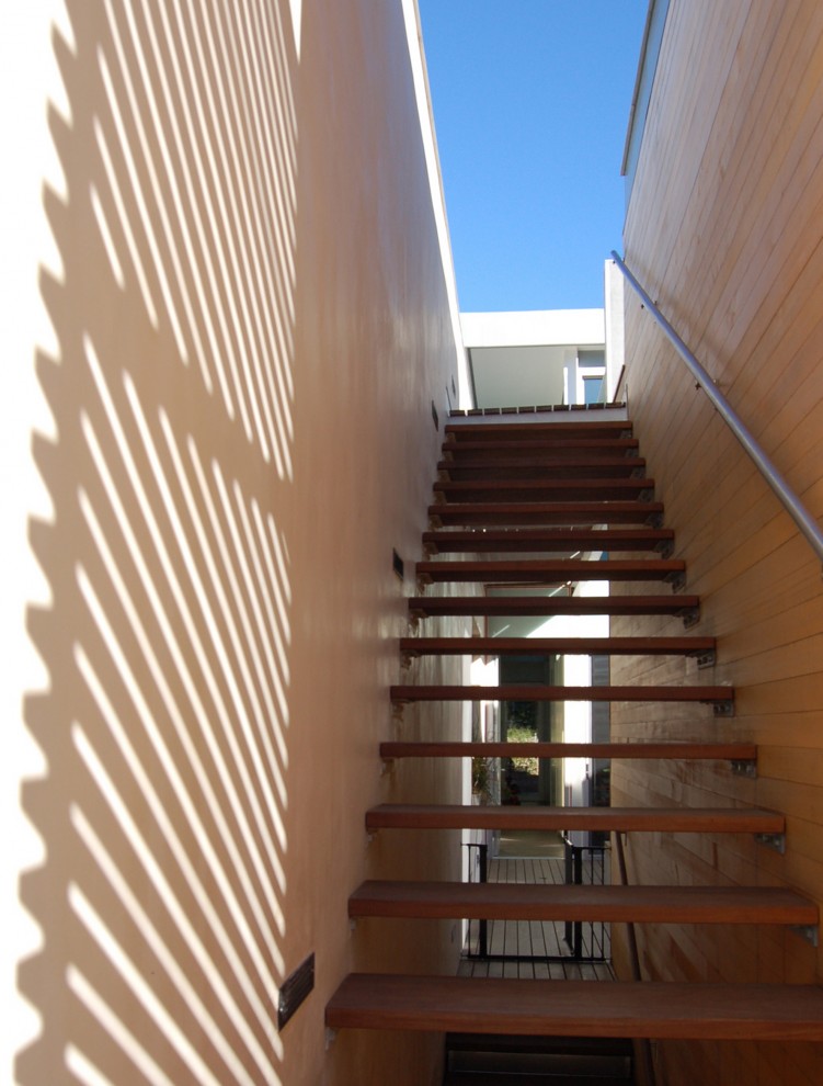Réalisation d'un escalier droit design de taille moyenne avec des marches en bois et un garde-corps en bois.
