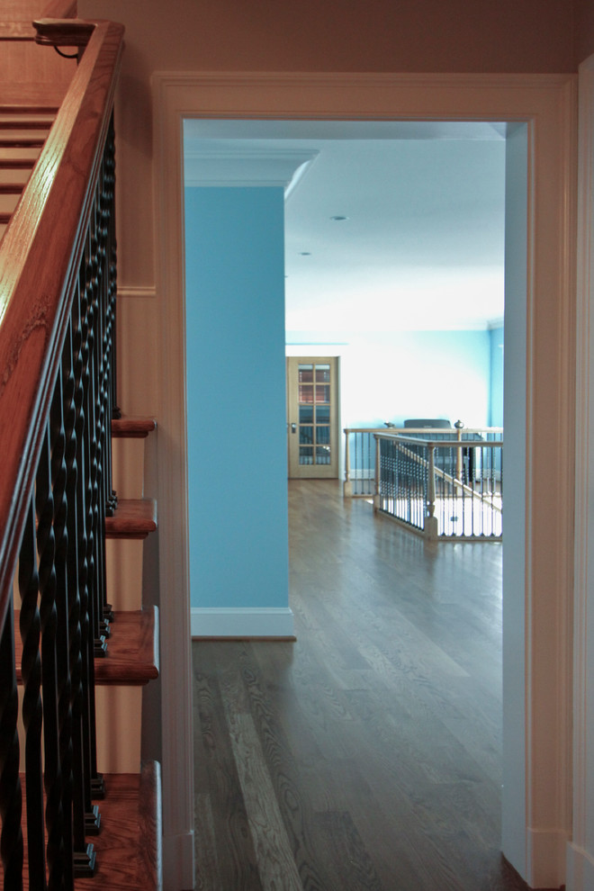 Photo of an expansive classic wood spiral metal railing staircase in DC Metro with wood risers.