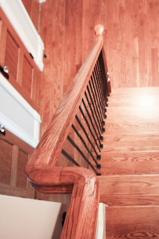 На фото: огромная винтовая деревянная лестница в классическом стиле с деревянными ступенями и металлическими перилами