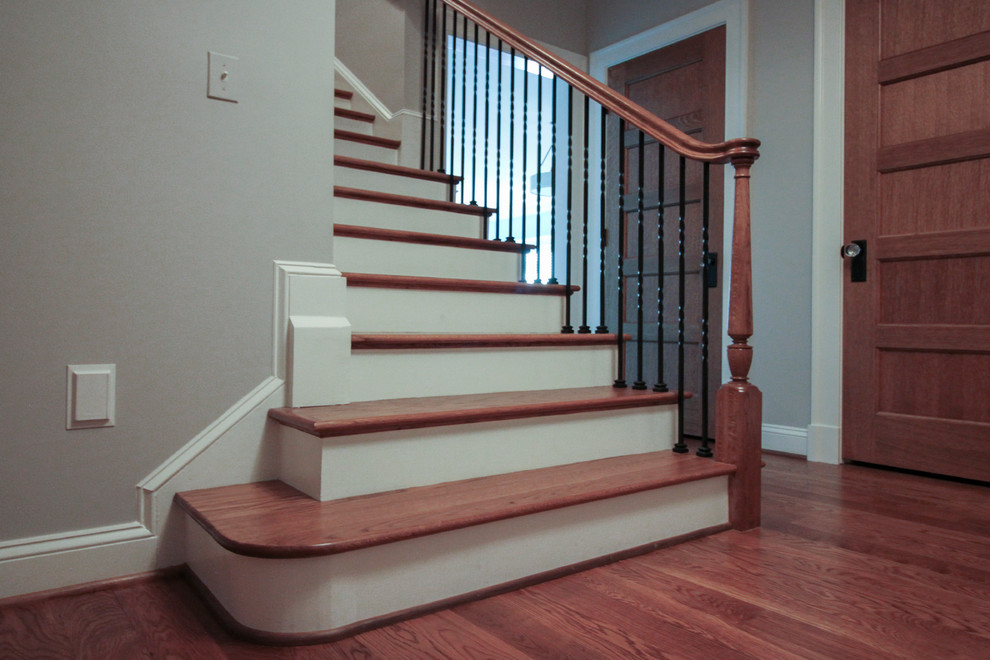 Expansive classic wood spiral metal railing staircase in DC Metro with wood risers.