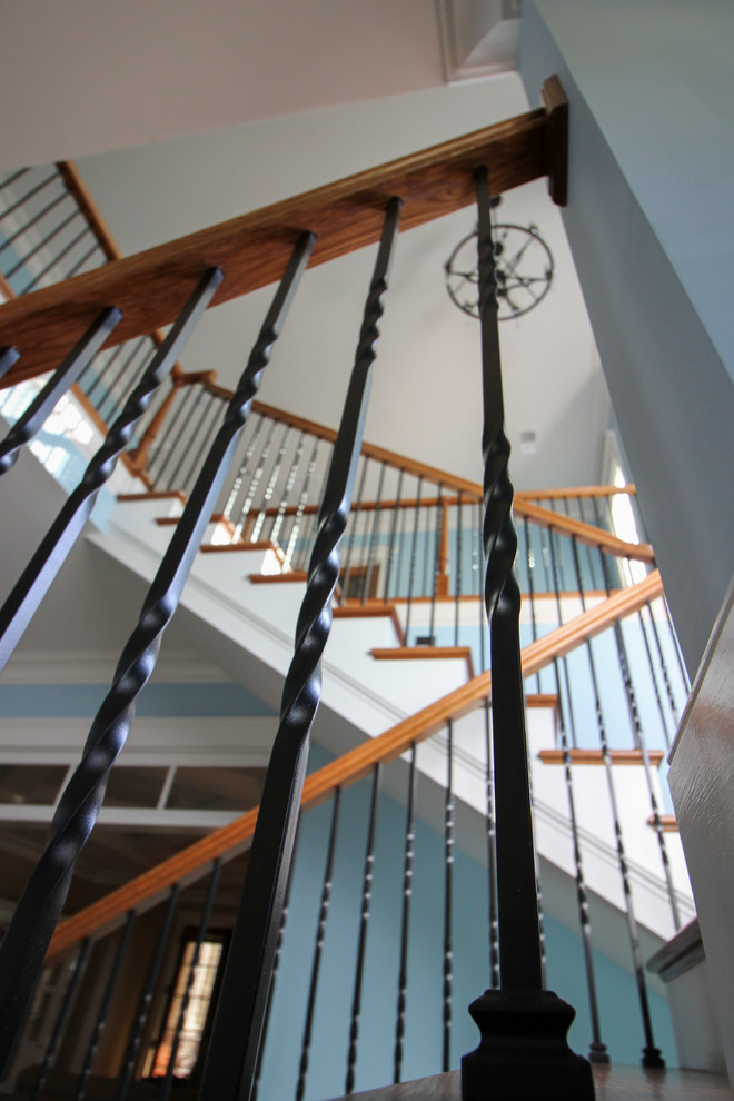 Источник вдохновения для домашнего уюта: огромная винтовая деревянная лестница в классическом стиле с деревянными ступенями и металлическими перилами