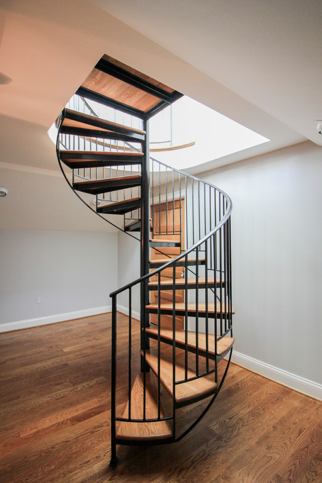 This is an example of an expansive traditional wood spiral metal railing staircase in DC Metro with wood risers.