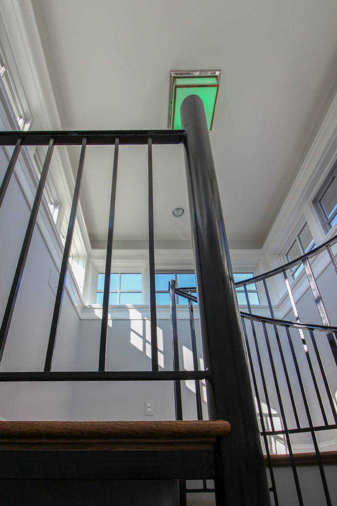 Пример оригинального дизайна: огромная винтовая деревянная лестница в классическом стиле с деревянными ступенями и металлическими перилами
