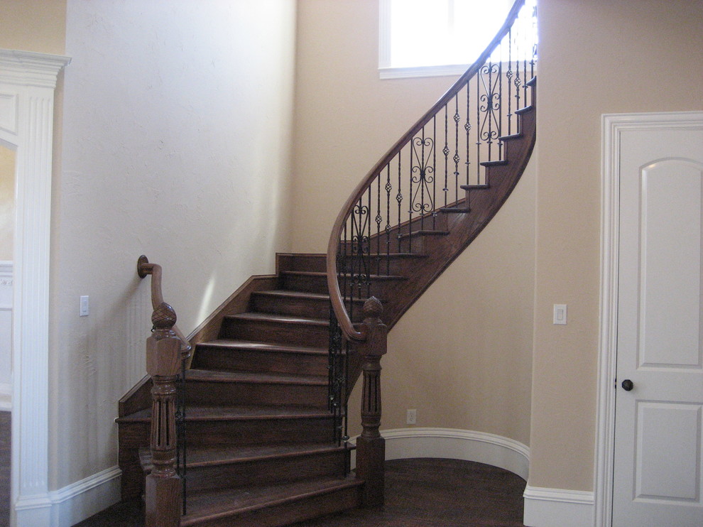 Imagen de escalera curva clásica de tamaño medio con escalones de madera y contrahuellas de madera