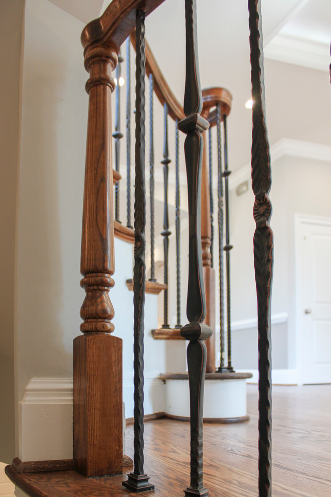 Large mediterranean wood curved mixed railing staircase in DC Metro with wood risers.