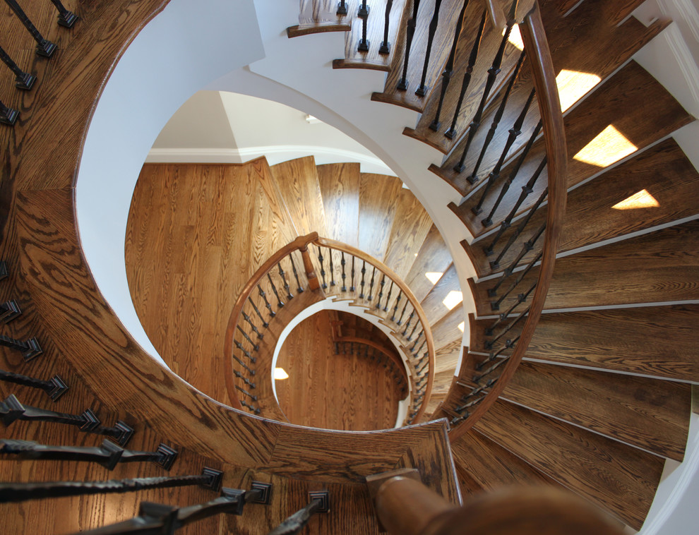 Inspiration for a large mediterranean wooden curved mixed material railing staircase remodel in DC Metro with wooden risers