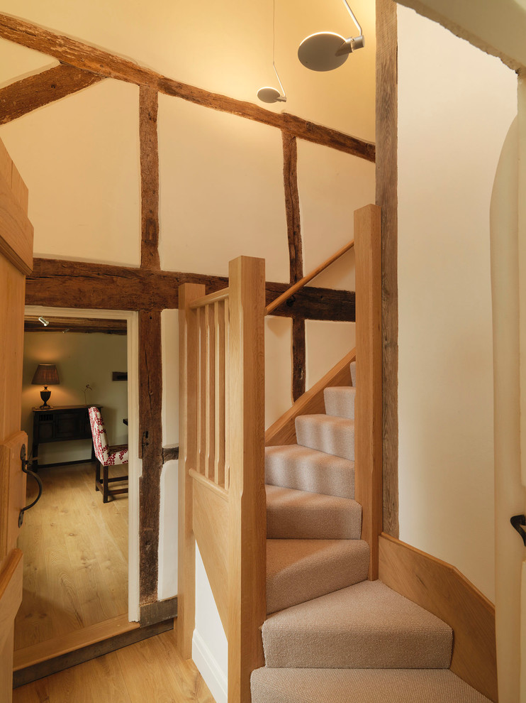 Photo of a large country carpeted l-shaped staircase in Hampshire with carpeted risers and feature lighting.