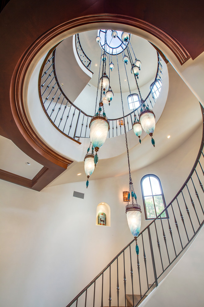 Photo of a large mediterranean wood spiral staircase in Los Angeles with wood risers.