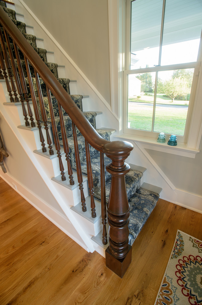 Imagen de escalera recta campestre grande con escalones de madera pintada, contrahuellas de madera pintada y barandilla de madera
