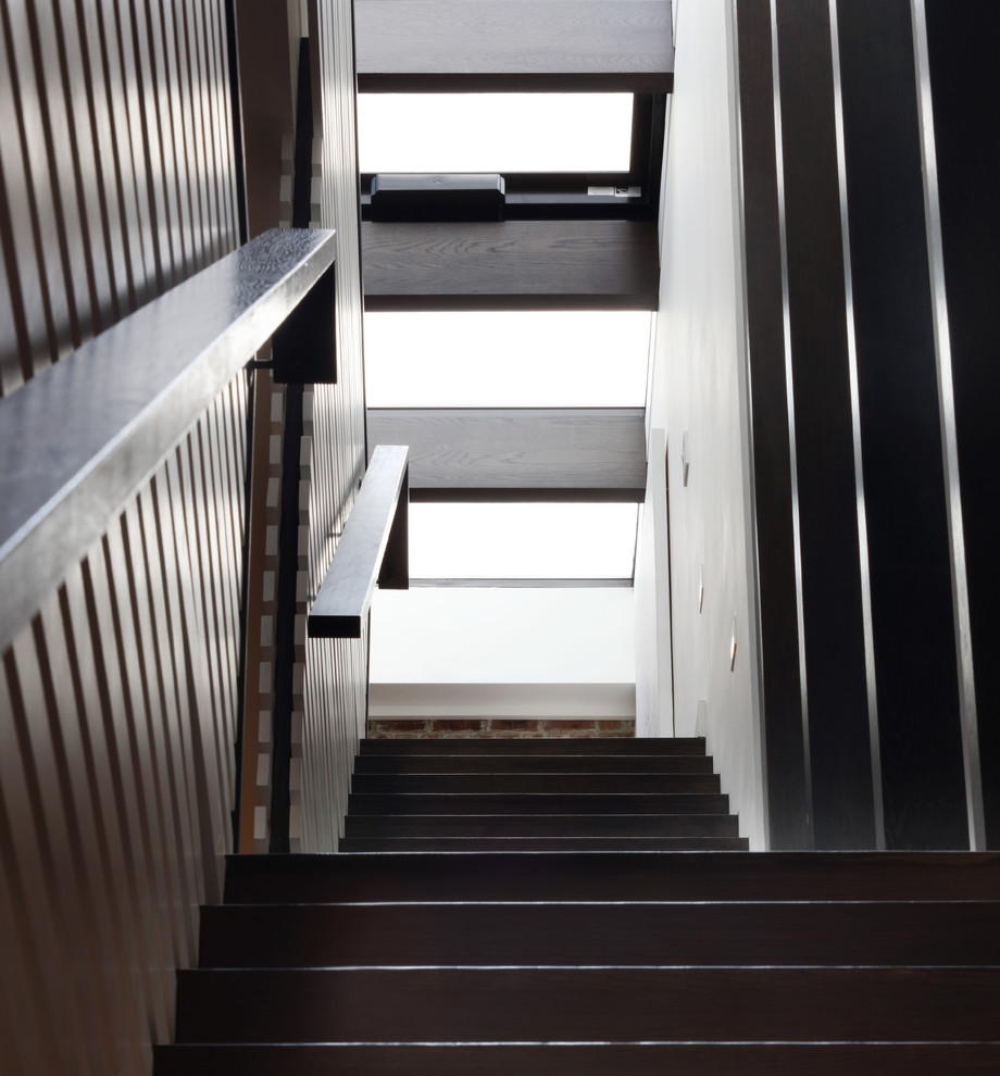 Immagine di una scala a rampa dritta minimalista di medie dimensioni con pedata in legno, alzata in legno, parapetto in legno e pareti in legno