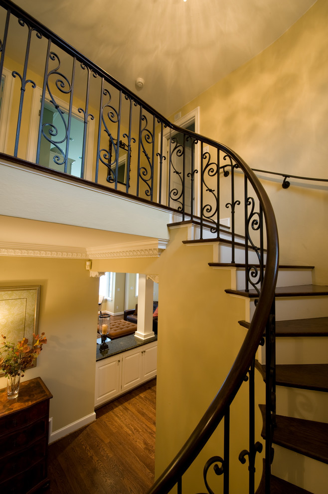 На фото: изогнутая лестница среднего размера в классическом стиле с деревянными ступенями и крашенными деревянными подступенками
