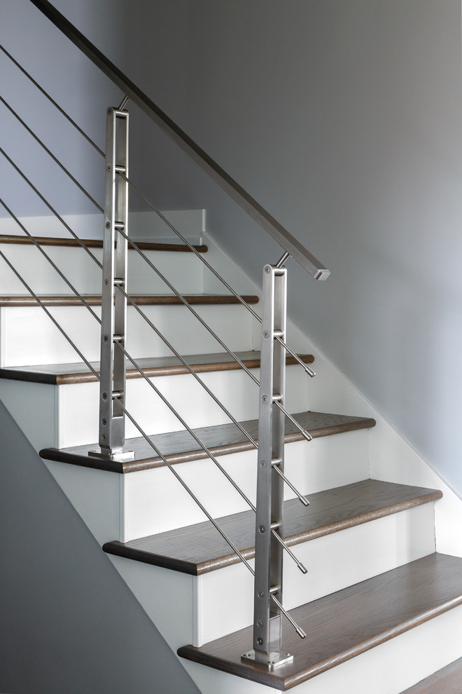 Aménagement d'un escalier droit contemporain de taille moyenne avec des marches en bois, des contremarches en bois et un garde-corps en métal.